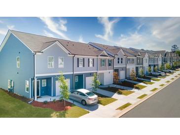 Charming exterior view of colorful townhomes with individual garages and landscaped yards, located in a vibrant community at 4285 Notting Hill Dr # 65, Atlanta, GA 30331