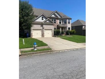 Two-story brick home with a well-manicured lawn and a two-car garage at 5253 Rosewood Pl, Fairburn, GA 30213