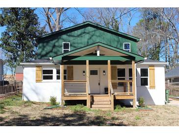 Charming renovated home featuring a quaint front porch with wood columns and railings and painted white brick at 1285 Mcclure Nw Ave, Atlanta, GA 30314