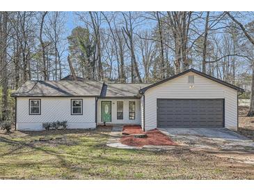 Charming single-story home with a gray garage door and a well-maintained front yard at 1669 Glen Arm Dr, Lithonia, GA 30058