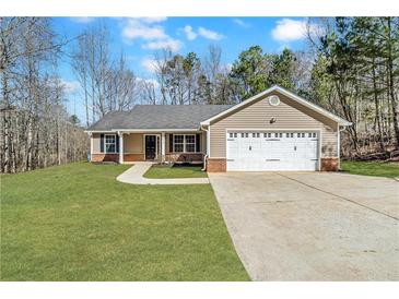 Charming single-story home featuring a two-car garage and a well-manicured lawn at 217 Lamb Rd, Moreland, GA 30259