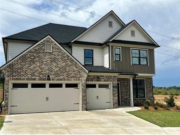 Two-story home with a three-car garage, brick and siding exterior, and well-maintained landscaping at 4024 Hosch Retreat Dr, Buford, GA 30519