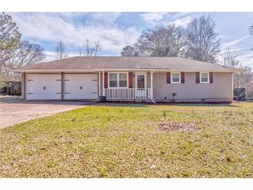 Charming single-story home featuring a spacious yard and a convenient two-car garage at 1408 Lake Paradise Rd, Villa Rica, GA 30180