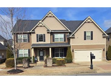 Charming two-story home featuring a two-car garage and a welcoming front porch at 651 Deer Springs Way, Loganville, GA 30052