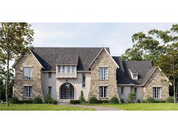 Stunning stone-and-shingle home featuring a arched entry, complemented by lush landscaping and a serene pathway at 133 Laurel Brook Ln, Canton, GA 30115