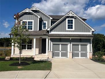 Charming two-story home with gray siding, white trim, a two-car garage, and well-kept lawn at 223 Willow St, Canton, GA 30114