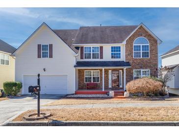 Charming two-story home with a combination of vinyl siding and brick facade with front porch at 4381 Prather Son Dr, Loganville, GA 30052