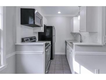 Cozy kitchen featuring white cabinets, stainless steel appliances, and tile backsplash at 86 De Arc Nw Pl, Atlanta, GA 30327