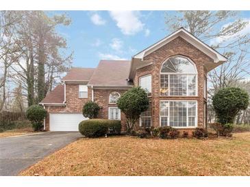 Beautiful two-story brick home with a well-manicured lawn and mature landscaping at 1647 Club Vista Trce, Stone Mountain, GA 30088