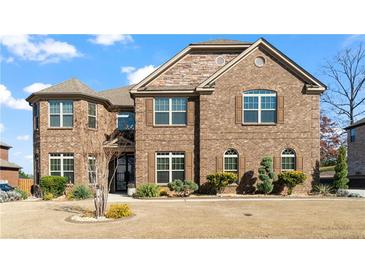 Charming two-story brick home featuring a manicured lawn and well-maintained landscaping at 5669 Casa Blanca Ln, Atlanta, GA 30331