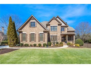 Beautiful brick home featuring a manicured lawn, detailed windows, and a covered front porch entry at 2953 Kings Walk Ave, Marietta, GA 30062