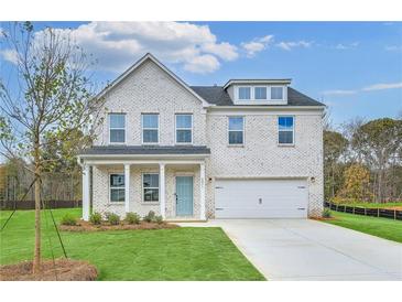 Charming two-story brick home featuring a manicured lawn and a light blue front door at 6074 Marigold Way, Atlanta, GA 30349