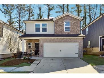 Charming two-story home with brick and stone accents, a two-car garage and a landscaped front yard at 1405 Lyon Way Dr, Lawrenceville, GA 30044