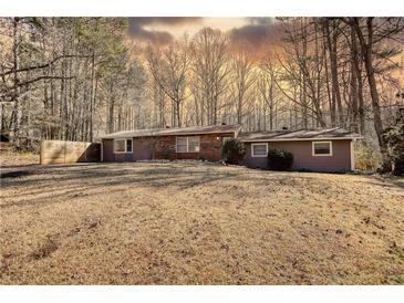 Charming one-story home with a brick accent and wooded surroundings, offering a serene setting at 115 Hollybrook Rd, Atlanta, GA 30349