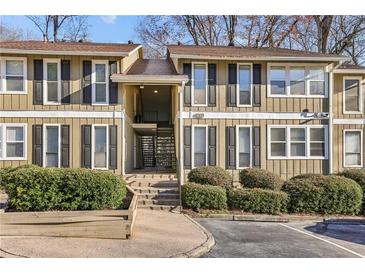 Inviting exterior of townhome featuring neutral siding, black shutters, and manicured landscaping at 5153 Roswell Rd # 10, Atlanta, GA 30342