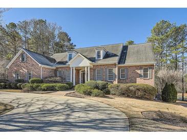 A beautiful brick home with a manicured lawn and a circular driveway at 1725 Patriots Nw Way, Kennesaw, GA 30152