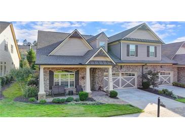 Charming two-story home featuring a stone and brick facade, covered porch, and well-manicured landscaping at 3220 Celebration Blvd, Suwanee, GA 30024