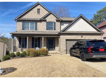 Charming brick two-story home featuring a welcoming front porch, dark shutters, and a well-maintained lawn at 526 Blue Mountain Rise, Canton, GA 30114