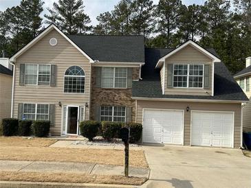 Charming two-story home featuring a two-car garage and neutral-colored siding at 6497 Snowden Dr, South Fulton, GA 30349