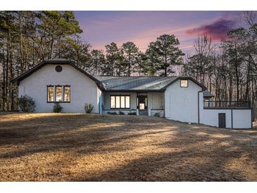 Charming single-story home with a textured facade, complemented by mature trees and a spacious front yard at 1675 Dodson Sw Dr, Atlanta, GA 30311