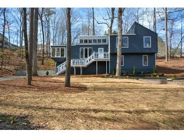 Charming two-story home with a modern design, complemented by a beautifully landscaped yard and inviting white staircases at 493 Willow Springs Dr, Marietta, GA 30068