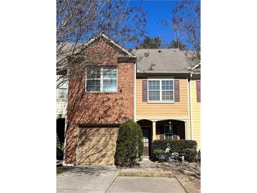 Charming townhouse featuring a brick facade and attached garage in a well-maintained community at 1426 Brookmere Way, Cumming, GA 30040