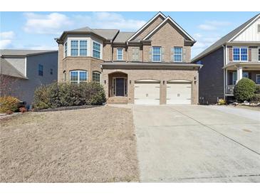 Charming two-story brick home with well-manicured lawn and attached two-car garage at 615 Ceremony Way, Acworth, GA 30102