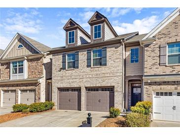 Charming two-story townhome featuring a brick facade, two-car garage, and well-maintained landscaping at 2069 Brightleaf Way # 123, Marietta, GA 30060