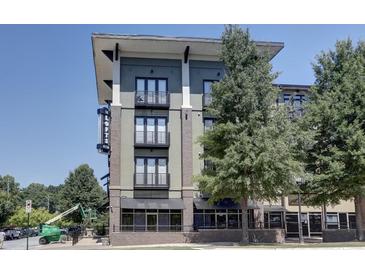 Contemporary condo building with brick accents, balconies, and well-maintained landscaping against a clear blue sky at 5300 Peachtree Rd # 2604, Atlanta, GA 30341