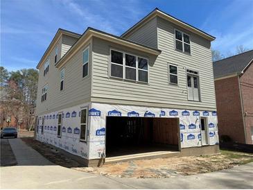 New construction home with gray siding, a two car garage, and modern windows at 2585 Governors Walk Blvd, Snellville, GA 30078