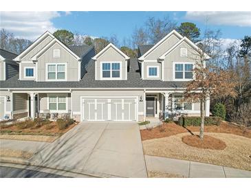 Charming townhouse with a two-car garage, neutral gray siding, and well-maintained landscaping at 334 Cherokee Station Cir, Woodstock, GA 30188