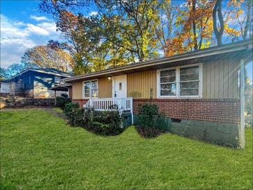 Charming single-story home with a brick foundation, well-manicured lawn, and a welcoming front porch at 1686 Valencia Rd, Decatur, GA 30032