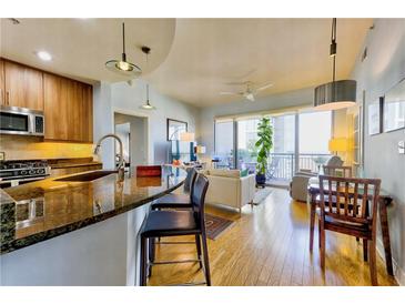 Bright condo featuring an open floor plan with a sleek kitchen, hardwood floors, and a balcony with city views at 222 12Th Ne St # 1808, Atlanta, GA 30309