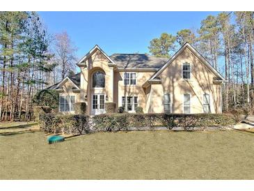 Stately two-story home featuring a manicured lawn and symmetrical design at 551 Lees Mill Rd, Fayetteville, GA 30214