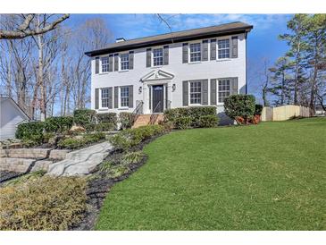 Charming two-story home with landscaped front yard, freshly painted white brick and black shutters at 2250 Deer Oaks Trl, Lawrenceville, GA 30044