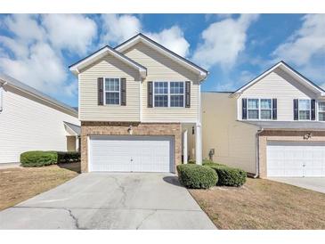 Charming two-story home features a brick-accented front, attached garage, and well-maintained landscaping at 6462 Splitpine Ct, Atlanta, GA 30349