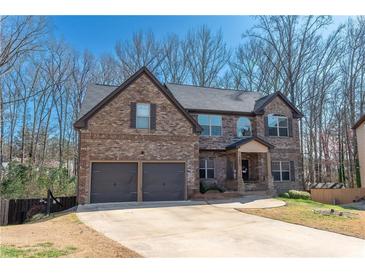 Attractive two-story brick and stone home with a two-car garage and well-maintained front yard at 5809 Savannah River, Atlanta, GA 30349