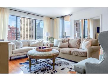 Bright living room featuring large windows with city views, hardwood floors, and stylish furniture at 3481 Lakeside Ne Dr # 2207, Atlanta, GA 30326