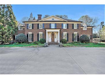 Beautiful two-story brick home with a manicured front lawn and a grand driveway at 3000 Rivermeade Nw Dr, Atlanta, GA 30327