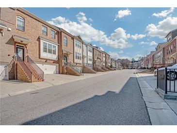 Charming townhomes with brick exteriors, individual garages, and landscaped front steps under a blue sky at 6441 Se Brookside Blvd, Mableton, GA 30126