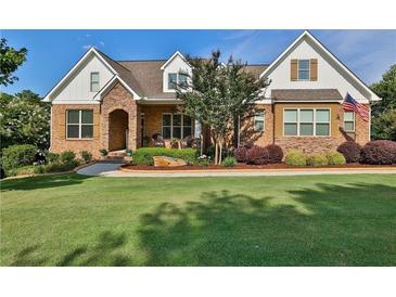 Charming brick home boasts a manicured lawn, manicured landscaping, and inviting curb appeal at 102 Glenmill Way, Woodstock, GA 30188