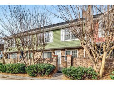 Charming two-story townhouse featuring a brick facade, landscaped front yard, and inviting entrance at 307 Adair St # 7-E, Decatur, GA 30030