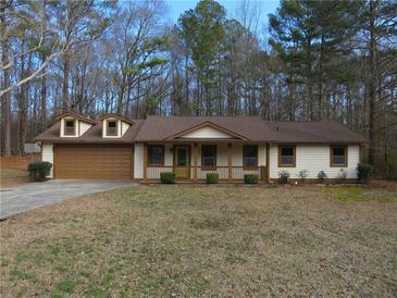 Charming single-story home featuring a well-manicured front lawn and an attached two car garage at 6832 Shangrila Way, Riverdale, GA 30296