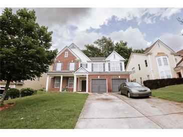 Charming two-story home featuring brick accents, white siding, a well-manicured lawn, and an attached two-car garage at 4617 Stone Lane, Stone Mountain, GA 30083