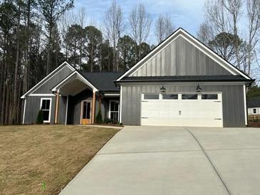 Attractive single-story home featuring a two-car garage, concrete driveway, and professionally landscaped yard at 554 Presley Farm Parkway, Rockmart, GA 30153