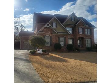 Beautiful two-story brick home with a well-manicured lawn and attached two-car garage at 1755 Riverpark Dr, Dacula, GA 30019