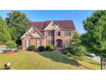 Beautiful brick two-story home with mature trees and a well-manicured front yard at 1755 Riverpark Dr, Dacula, GA 30019