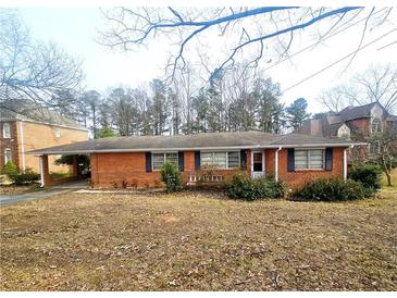 A cozy single-story home features a brick facade, a covered carport, and a well-kept lawn at 2480 Sewell Mill Rd, Marietta, GA 30062