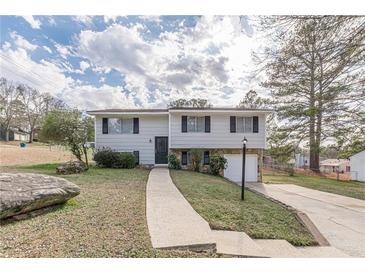 Charming split-level home with stone accents, landscaped yard, and single-car garage at 3025 Creel Rd, Atlanta, GA 30349