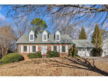 Charming brick home featuring dormer windows, a well-manicured lawn, and a two-car garage at 5352 Waterford Dr, Dunwoody, GA 30338